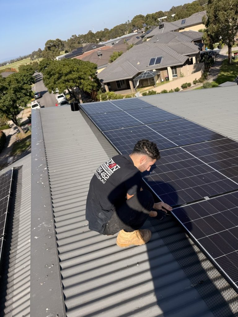 Amazon Pest technician installing bird proofing mesh around rooftop solar panels